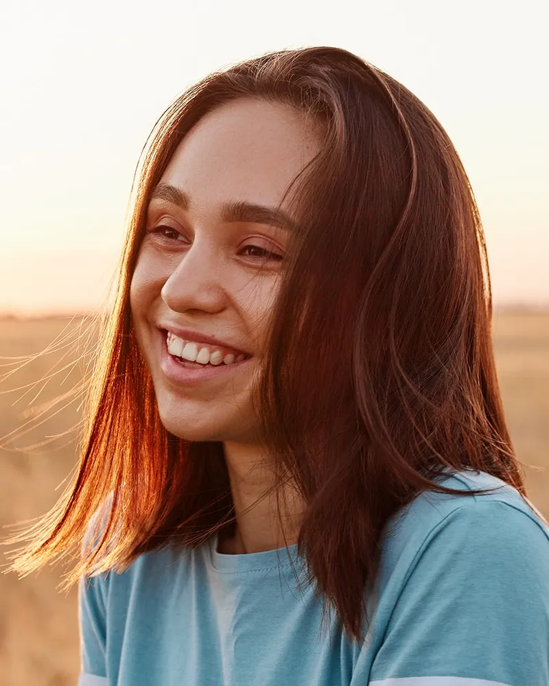 Girl with straight hair and nice smile at sunset