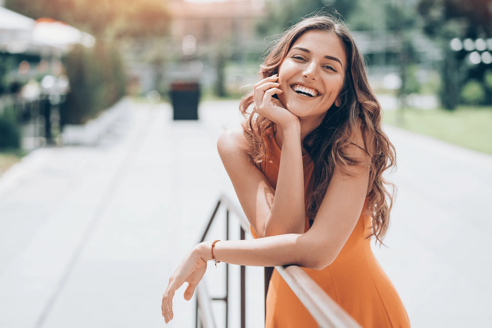 woman leaning against railing in the sun