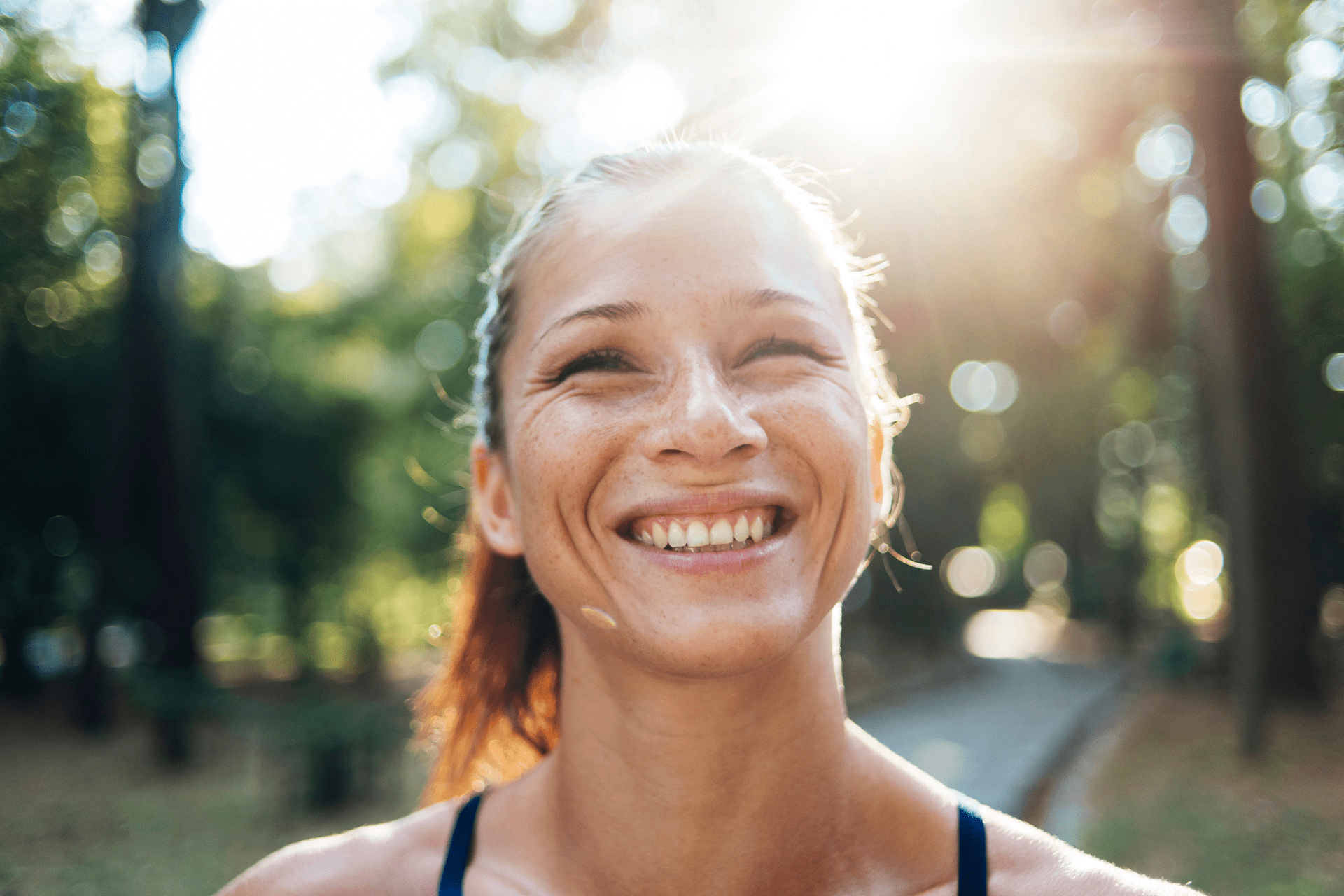 woman outside smiling with an overbite