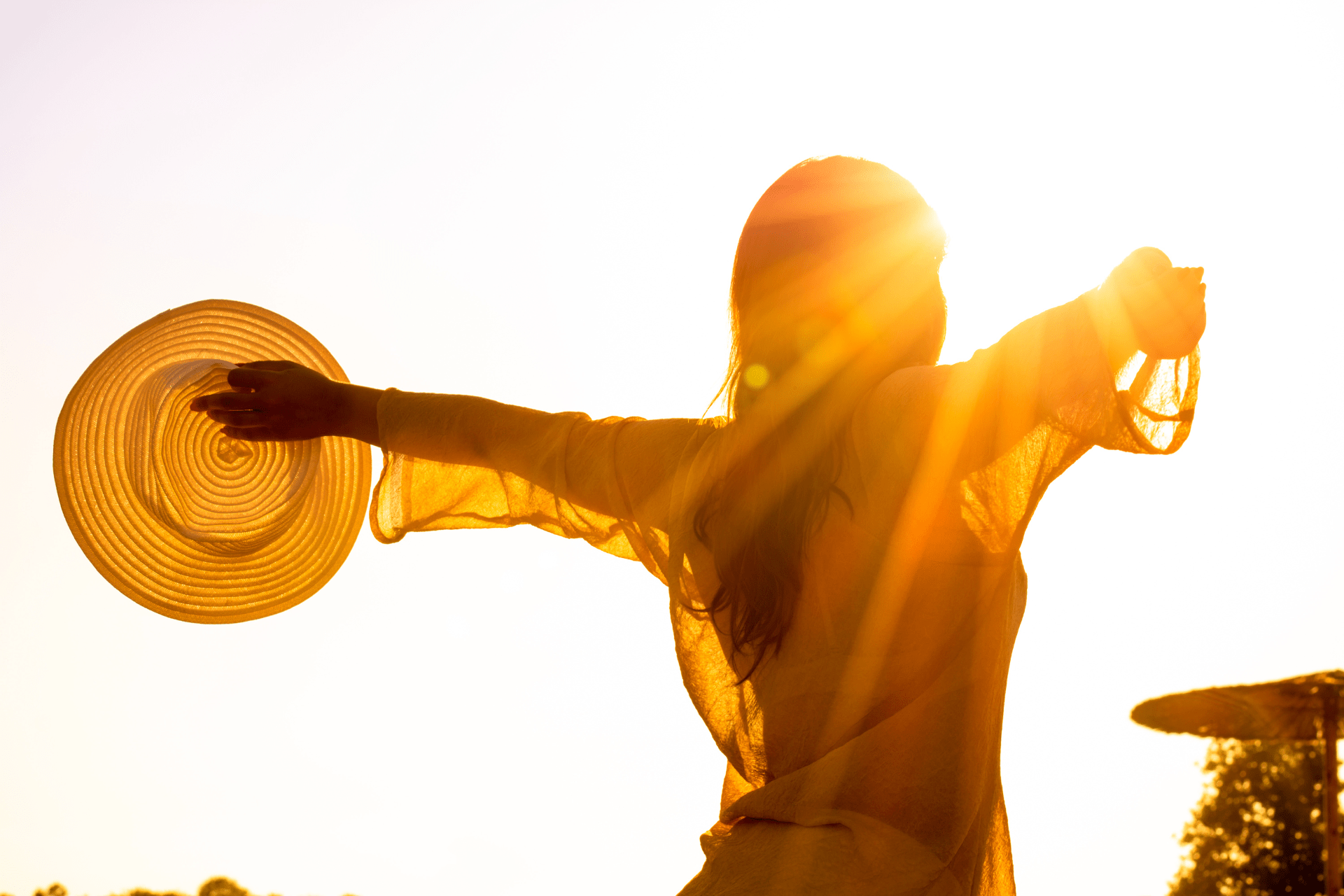 woman opening her arms to the sunlight