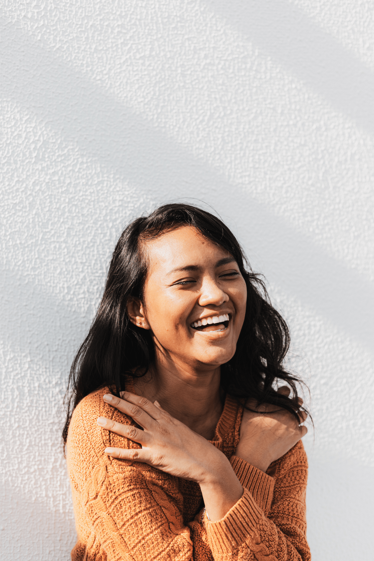 happy girl smiling in an orange sweater