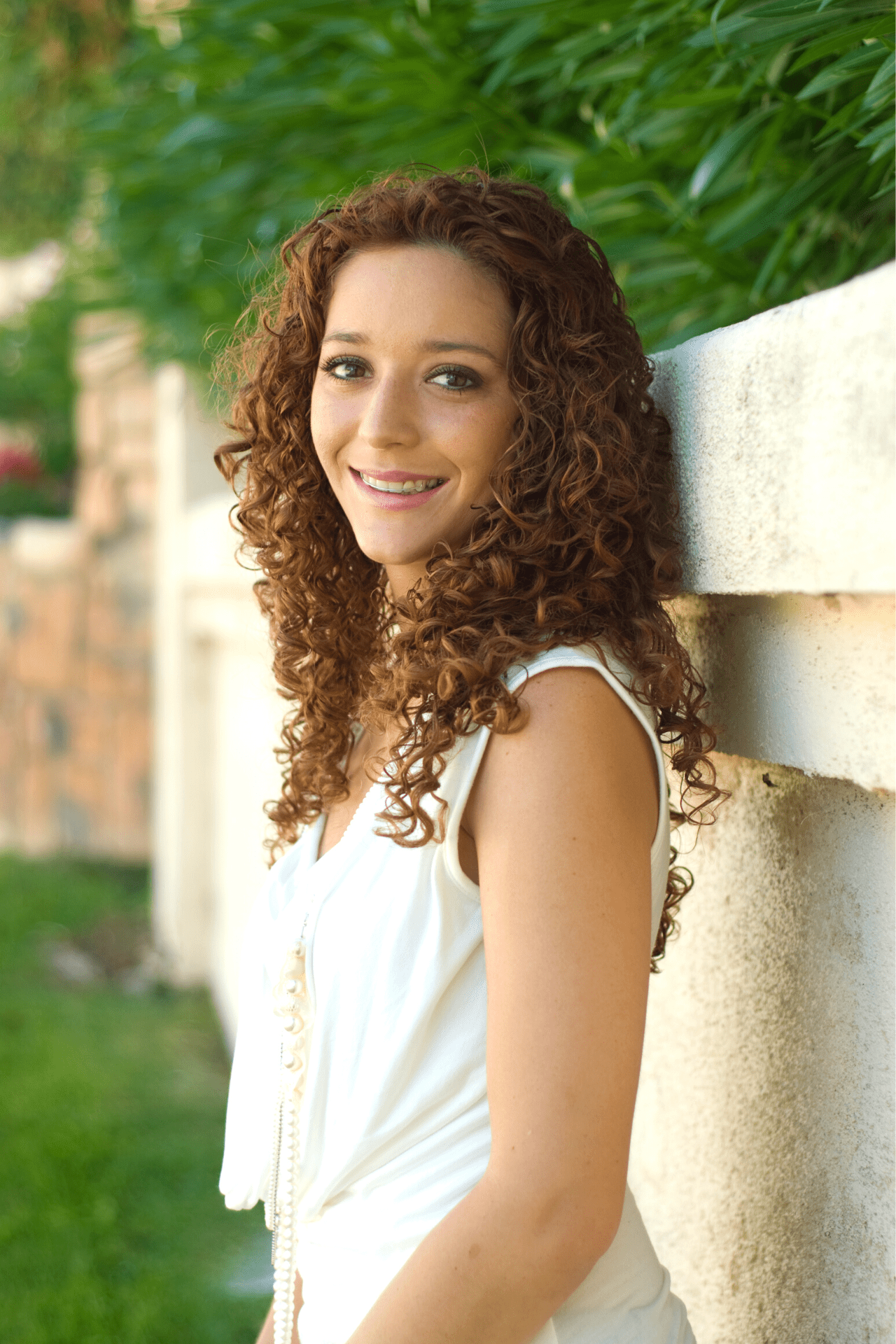 woman outside smiling with an overbite