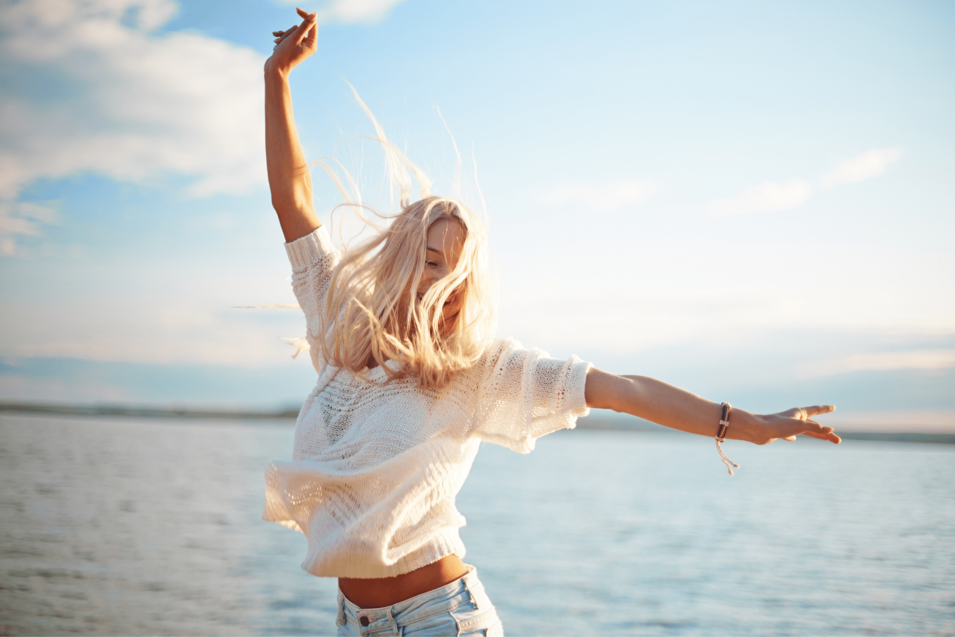 woman dancing on beach during a sunny day