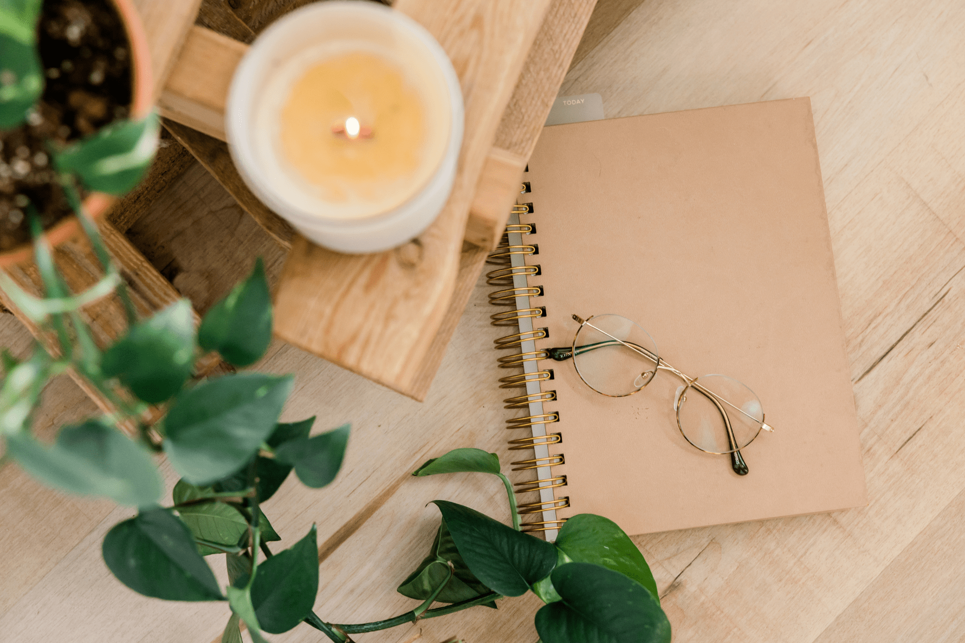 glasses and notebook next to a tea candle