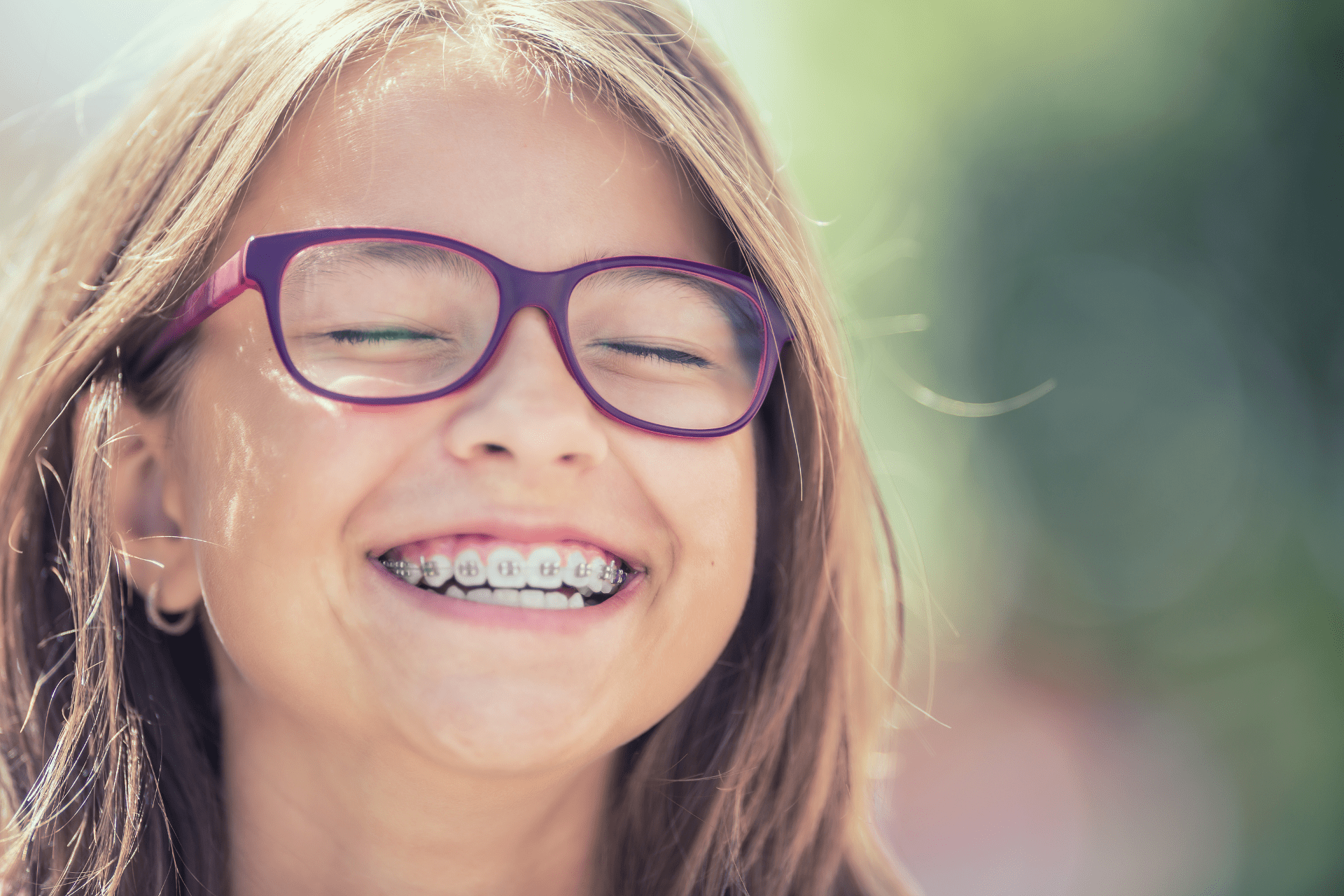 child smiling and pointing at his braces