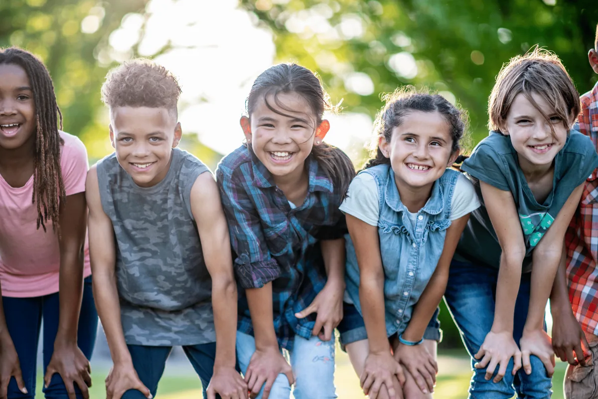 Group of smiling kids outside after braces for kids consultation at Pura Vida Orthodontics in the Twin Cities